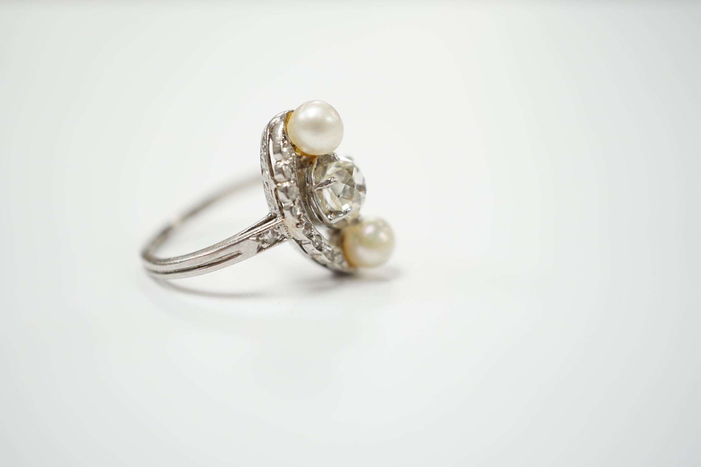 A white metal single stone diamond and two stone cultured pearl set elliptical shaped ring, size F, gross weight 4.3 grams.